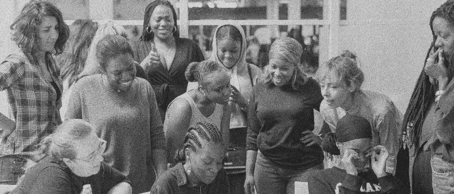 A group gathered closely around a table, looking down together.